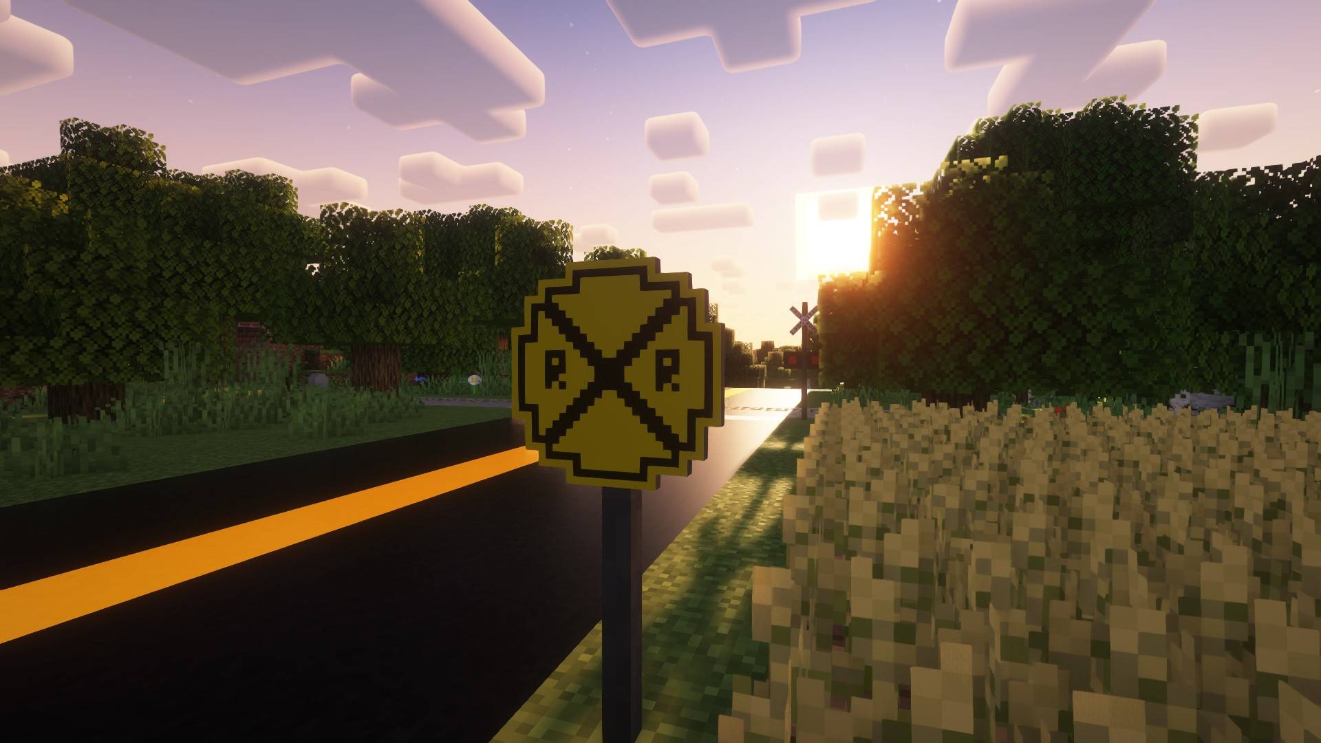 Знак предварительного предупреждения о железнодорожном переезде на сельской дороге рядом с полями. Знак предварительного предупреждения о железнодорожном переезде на сельской дороге рядом с полями.